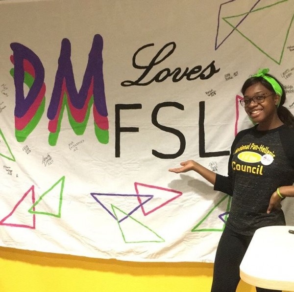 female student standing in front of dance marathon poster
